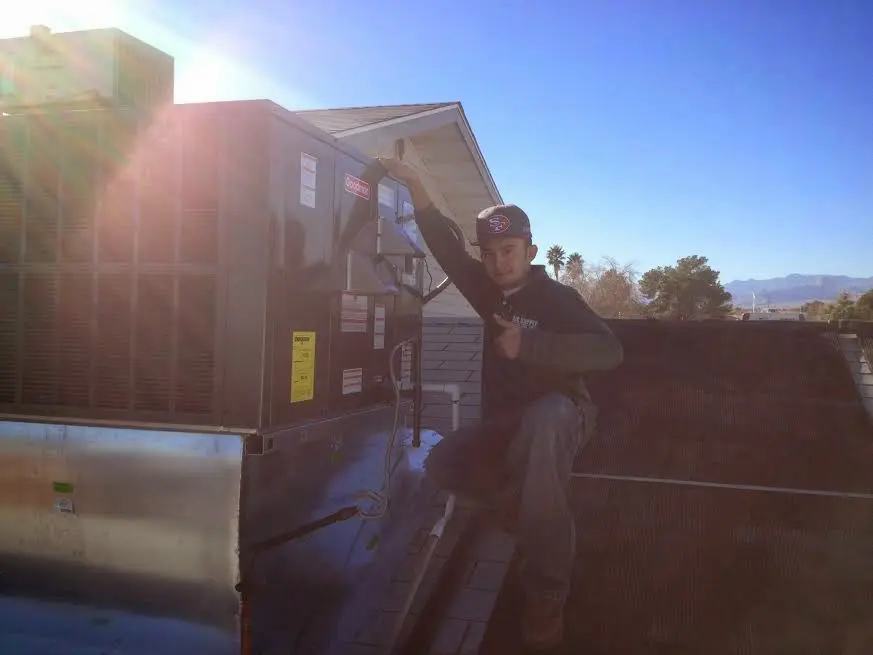 HVAC technician performing Boiler Repair on a rooftop unit in Waynesville